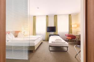 a hotel room with two beds and a desk at Hotel am Jakobsmarkt in Nuremberg