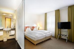 a hotel room with a bed and a sink at Hotel am Jakobsmarkt in Nuremberg