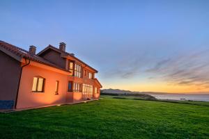 a house on a hill with the ocean in the background at Mirador del Mar in Oviñana