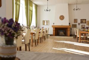 a dining room with a table and chairs and a fireplace at Guest House Ongal in Krushuna
