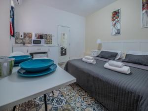 Un dormitorio con 2 camas y una mesa con platos. en Valletta Ajkla Mansion, en La Valeta