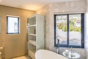a bathroom with a tub and a sink and a window at Lions Eye Luxury Apartments in Cape Town +38 photos