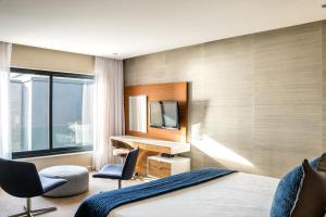 a hotel room with a bed and a desk and chair at Lions Eye Luxury Apartments in Cape Town