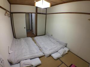 um pequeno quarto com 2 camas e um espelho em Kenroku Haitsu 301 em Kanazawa