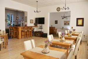 a dining room and living room with tables and chairs at Guest House Ongal in Krushuna