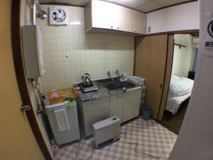 a small kitchen with a sink and a bed at Kenroku Haitsu 302 in Kanazawa