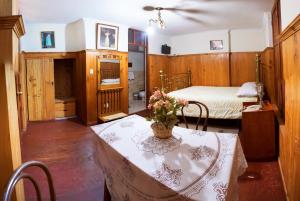 een slaapkamer met een tafel met een vaas met bloemen erop bij Hotel Museo Casona Ugarte Leon in Concepción