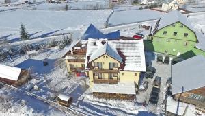 an aerial view of a house in the snow at Pensiunea Popasul Iancului in Mărişel