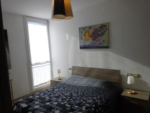 a bedroom with a black and white bed and a window at Due Agosto Apartments in Bologna