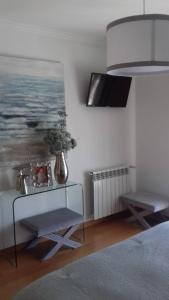 een slaapkamer met een glazen tafel en een schilderij aan de muur bij Vivenda Valverde in Nazaré