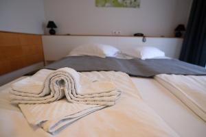 Dos camas con toallas encima. en Pensiunea La Broscuta en Cîmpia Turzii