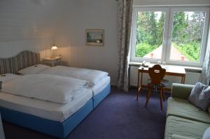 1 dormitorio con 2 camas, mesa y sofá en Finkenhof - Haus Meersmannufer, en Hannover