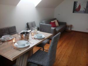 - une salle à manger avec une table, des chaises et un canapé dans l'établissement Appartment Stroblhof, à Aich