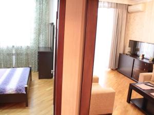 Zimmer mit einem Bett und einem Wohnzimmer in der Unterkunft My sweet home on Gadzhibekova 105-119 in Baku