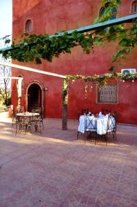 einen Tisch und Stühle vor einem roten Gebäude in der Unterkunft Latifa House in Marrakesch