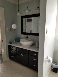 ein Badezimmer mit einem Waschbecken und einem großen Spiegel in der Unterkunft Woodland Retreat - Wanderlust in Woodland