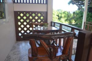 a wooden chair and table on a porch at Thosawan Resort ทศวรรณ รีสอร์ท in Khong Chiam