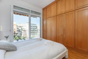 a bedroom with a bed and a large window at Flateli Aribau in Barcelona