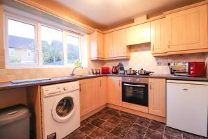 a kitchen with a washing machine and a washer at Royal Oak Home in Wythenshawe