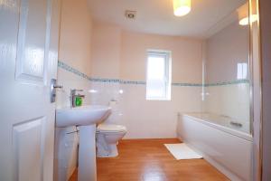 a bathroom with a sink and a toilet and a tub at Royal Oak Home in Wythenshawe +20 photos