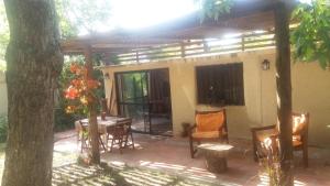 ein Haus mit einer Terrasse mit einem Tisch und Stühlen in der Unterkunft Los Mochos Portezuelo in Punta del Este