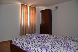 1 cama con estampado de cebra en un dormitorio con ventana en Vila Lotus, en Murighiol
