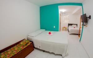 a bedroom with two beds and a blue wall at Pousada Barros in Jericoacoara