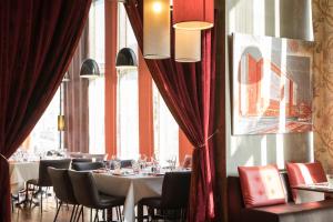 - un restaurant avec des tables et des chaises dans une salle dotée de fenêtres dans l'établissement Mercure Lyon Centre - Gare Part Dieu, à Lyon