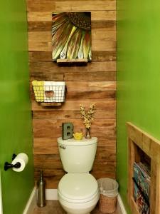 a bathroom with a toilet with a wooden wall at Woodland Retreat - Wanderlust in Woodland