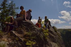 a group of people sitting on top of a rock at Pensiunea Popasul Iancului in Mărişel