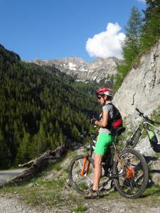 Un uomo in piedi vicino alla sua bici su una montagna di Ferienhäuser Stohl a Mariapfarr