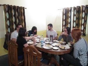 a group of people sitting around a table eating food at Hotel The Village Heart in Sawāi Mādhopur