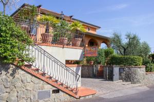 a house with a staircase and a stone wall at Le Quattro Stagioni in Massa