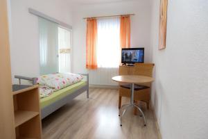 a bedroom with a bed and a table and a window at Germania Beck in Hülben