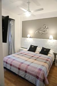 um quarto com uma cama grande e um cobertor xadrez em Dodo Suites em Mar del Plata