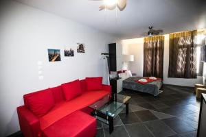 a living room with a red couch and a bed at Trendy Living in Monastiraki in Athens