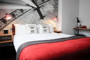 ロンドンにあるザ ウェリントン ホテルのベッドルーム1室(赤毛布付きの大型ベッド1台付)