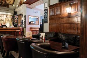 un restaurante con sillas de cuero y un bar en The Wellington Hotel, en Londres