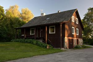 a brown house with a black roof at Tuhala Jarve Talu in Tuhala