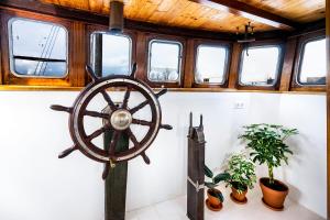 an old wooden steering wheel in a room with plants at Asile Flottant in Amsterdam