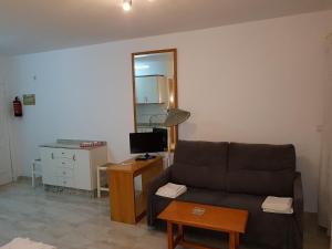 salon z kanapą i biurkiem z lustrem w obiekcie Apartamentos Olympia Garden w mieście La Manga del Mar Menor