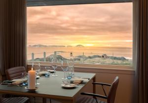 a table with wine glasses in front of a window at Hotel Arctic in Ilulissat