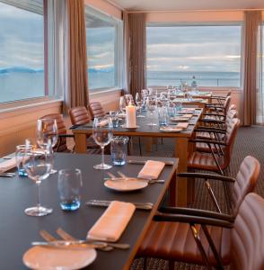 a dining room with tables and chairs and windows at Hotel Arctic in Ilulissat +37 photos