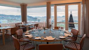a restaurant with tables and chairs and a large window at Hotel Arctic in Ilulissat