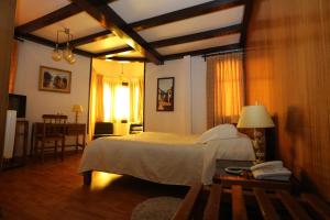 a bedroom with a bed and a table with a phone at Hotel Vegas in Santiago