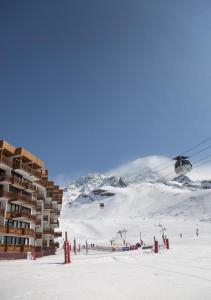 a ski resort with a ski lift in the snow at Residence Tourotel in Val Thorens