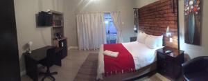 a bedroom with a bed and a desk and a window at Tranquil House B&B @ 1 College Ave in Queenstown