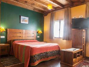 a bedroom with a bed and a flat screen tv at Apartamentos Rurales Les Martes in Felechosa
