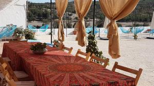 a table with a red table cloth and wooden chairs and a table with a table at Herdade da Maxuqueira in Gavião