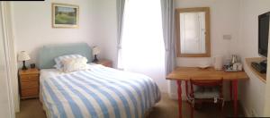 
a bedroom with a bed and a desk at Doune Guest House in St. Andrews
